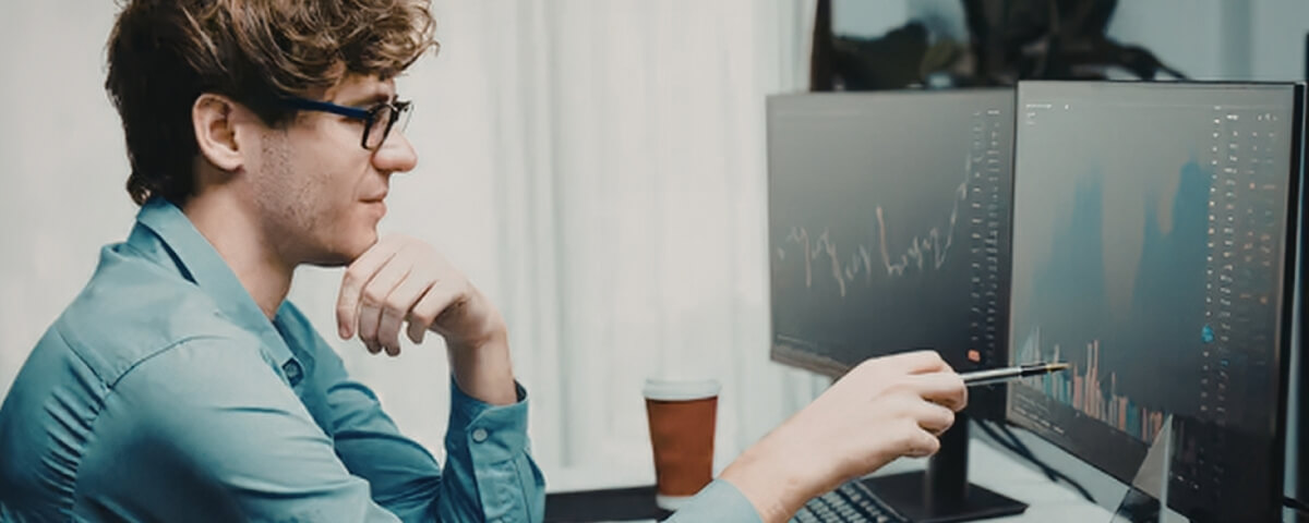 Technician analysing system data on multiple screens, illustrating the investment required for secure and effective IT support in hybrid work environments