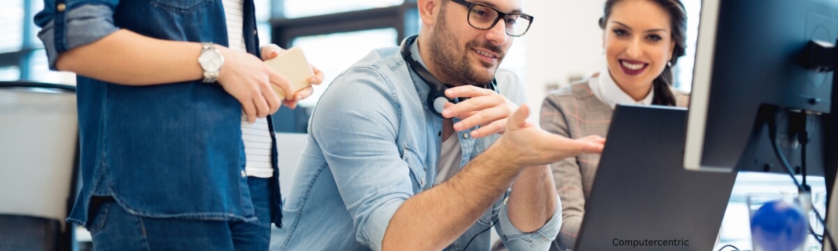 Collaborative IT support team working together at a computer, illustrating best practices for managing outsourced IT partnerships and avoiding common pitfalls