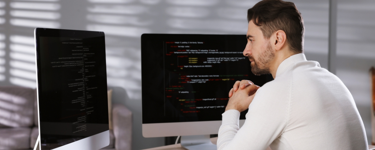 Technician analysing systems on multiple monitors, showing how IT support adapts to manage hybrid and distributed work environments