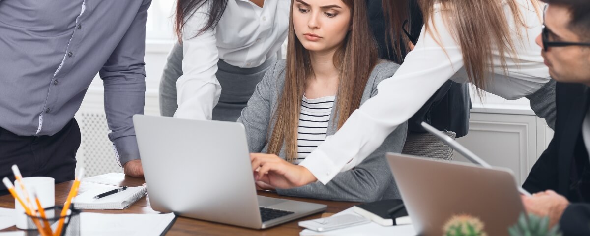 Office team gathered around a laptop while responding to a serious IT or ransomware-related incident