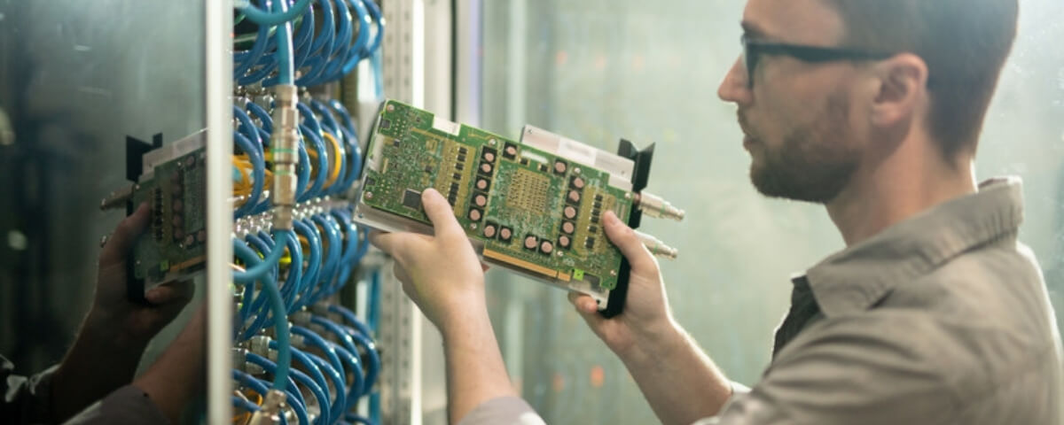 IT engineer checking hardware next to a network cabinet with patch cabling