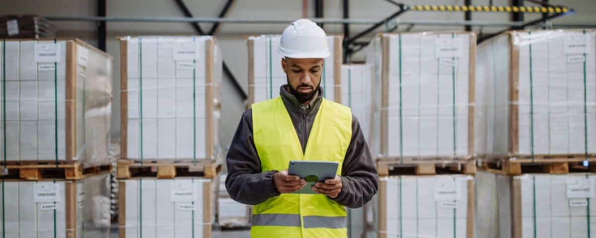 Warehouse worker in hi-vis using a tablet connected to the site network